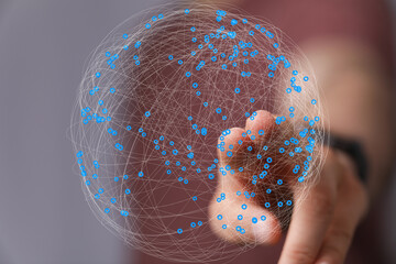 Abstract image of a hand interacting with a digital global network. Represents connectivity,...