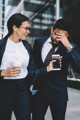 Modern colleagues walking in street in summer