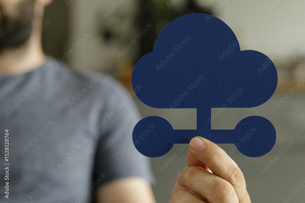 Aufkleber Close-up of a person holding a paper cutout of a cloud with network connections, symbolizing cloud computing and networking.