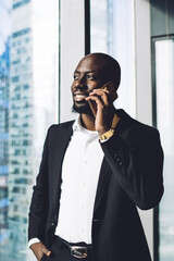 Happy executive man talking on smartphone in office
