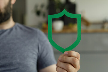 Image of a man holding a green shield, representing safety, security, and protection.