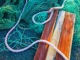 Fishing gear scattered on a dock at sunset highlighting ropes, wooden planks, and fishing nets