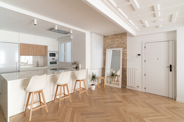 Cocina abierta al salón: vivienda reformada moderna de diseño, sin tabiques entre la cocina y el salón, donde predominan los tonos blancos y madera