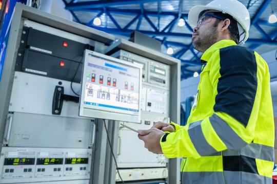 Electrical engineer woman checking voltage at the Power Distribution Cabinet in the control room,preventive maintenance Yearly,Thailand Electrician working at company