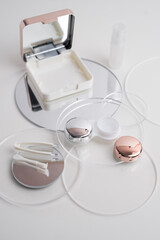Contact lenses, case and bottle with solution and eye drops on white background. Eye health and care, vision, ophthalmology concept, close-up 