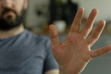 Close-up image of a man's hand gesturing to stop.  Perfect for concepts of rejection, denial, or...