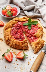 Delicious homemade strawberry galette with almond petals baking on parchment paper