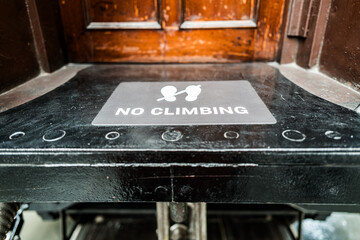 Shallow focus of a No Climbing sign seen on an old railway passenger carriage within a railway...