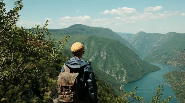 Female hiker with arms wide open standing at the edge of a viewpoint banjska stena in Tara National Park, embracing the beauty of the Drina River canyon. Rear view. Travel in Serbia country concept