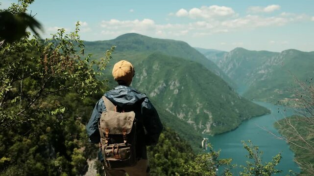 Female hiker with arms wide open standing at the edge of a viewpoint banjska stena in Tara National Park, embracing the beauty of the Drina River canyon. Rear view. Travel in Serbia country concept