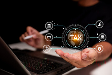 A person operates a laptop while highlighting a digital tax icon surrounded by finance-related symbols, symbolizing online taxation and financial management.