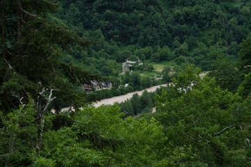 A river flowing at the foot of mountains in Georgia, cloudy sky