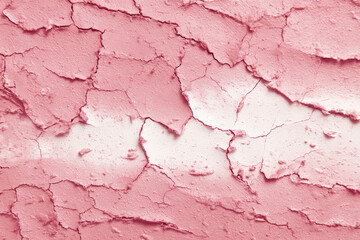 Fototapeta premium Cracked pink clay mask texture with dry effects, showcasing abstract pattern. surface appears rough and textured, creating visually interesting design