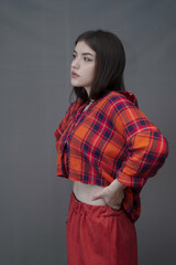 Confident Young Woman in Red Plaid Shirt and Long Buttoned Skirt Posing Indoors