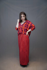 Confident Young Woman in Red Plaid Shirt and Long Buttoned Skirt Posing Indoors