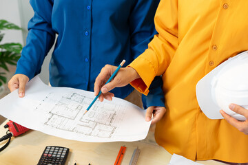 Two people reviewing architectural plans with focus and collaboration
