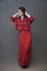 Confident Young Woman in Red Plaid Shirt and Long Buttoned Skirt Posing Indoors
