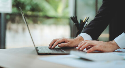 Portrait of typing on laptop computer. Working on filling out documents, income, expenses and...
