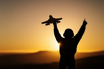 A silhouette of an aviator holding up their toy airplane against the backdrop of a sunset,