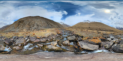 A 360 by 180 degrees equirectangular panorama of Mountain river with rocks at springtime in mountain gorge at sunny afternoon