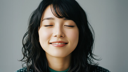 目を閉じて微笑む穏やかで幸せな女性のクローズアップ