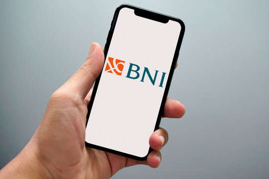 Hand holding smartphone showing bni bank logo on screen
