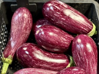 Ripe dark eggplants in a cardboard box for sale in an elite supermarket. Healthy eating. Close-up