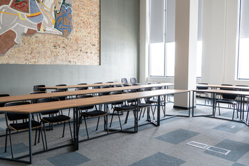 Empty room with tables and chairs for studying. University or school auditorium. Furniture in the interior. Modern style. Back to school. Study education