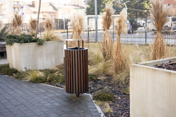Wooden Public trash can on a city street filled with garbage. Garbage bin in park with blurred background