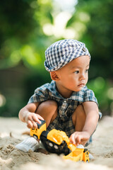Curious toddler playing with sand outdoors, developing fine motor skills, creativity, and cognitive growth through hands-on exploration in a safe, natural learning environment under sunlight