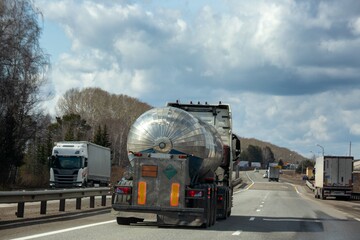 A tanker truck drives along a highway outside the city
