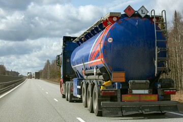 A tanker truck drives along a highway outside the city
