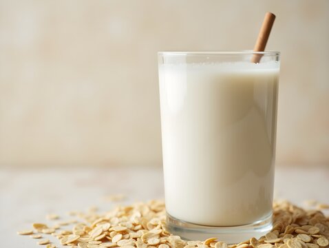 Oatmeal milk with cereal grain. Glass with protein diet. White fresh ingredient with copyspace. Antioxidant background with place for text. Vegetarian oat drink with flakes