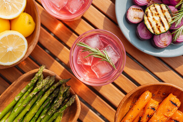 Vibrant summer picnic scene of refreshing cocktails, fresh produce, inviting a sense of culinary delight. A top-down shot captures a feast for the senses with vivid colors.