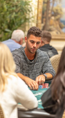 Obraz premium A focused man engages in a serious game of poker, strategizing his next move, captured with the focus and intensity of the game, highlighting the stakes and thrill of the table.