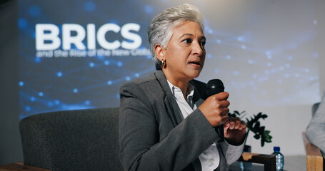 Mature woman, conference or presentation for public speaking, development seminar or business event. Convention, speech and workshop for economy talk in auditorium with microphone, keynote and summit