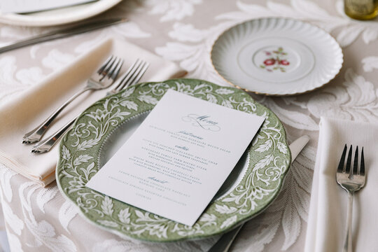 Elegant dining table set for a special occasion featuring a beautifully designed menu and fine tableware