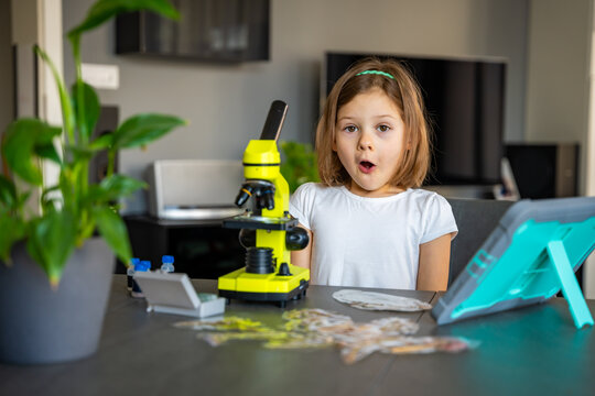 Child amazed reaction after seeing something for the first time under a microscope. Concept of scientific discovery and the joy of learning