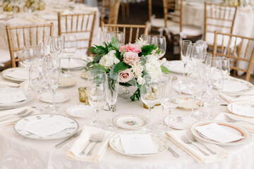 Elegant round table setup for a formal dining event featuring floral centerpiece and exquisite tableware