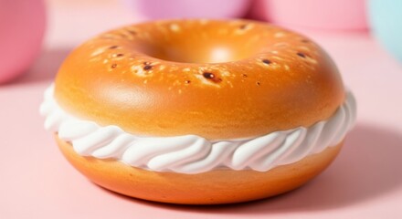 A close up of a donut with white frosting on a pink surface in a soft focus studio setting shot