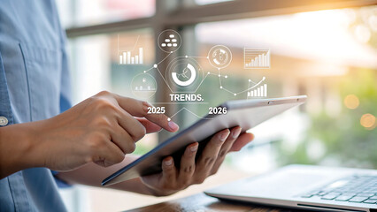 Business professional using futuristic tablet interface to analyze market trends and data projections for 2025 and 2026