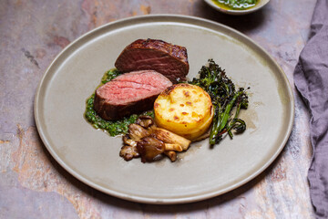 Fillet steak with potato stack, oyster mushrooms and chimichurri sauce