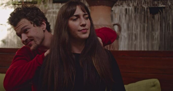 A young couple enjoys a relaxing moment together as the man gives the woman a soothing shoulder massage.