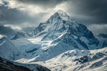 Obraz premium Majestic snow capped mountain peak under dramatic sky