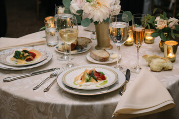 Elegant dinner table setting with gourmet dishes and drinks during a formal event in the evening