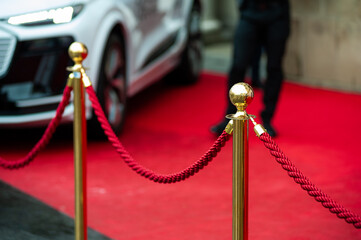 Red carpet event barrier with gold stanchions and red rope, luxury entrance to VIP zone or...