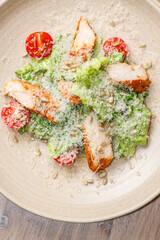 Fresh salad with grilled chicken, cherry tomatoes, and sunflower seeds served in a rustic bowl