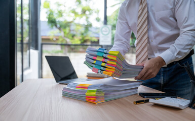 Overwhelmed Businessman Holding Stack of Documents