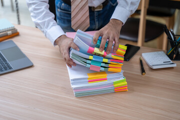 Man Organizing Documents with Color-Coded Tabs