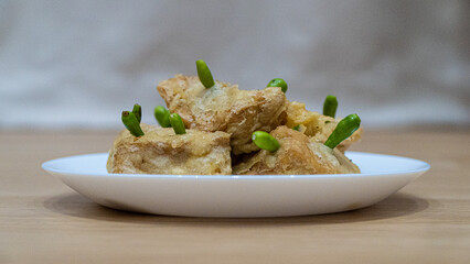 Crispy fried tofu, healthy cooking soybean block tofu in white plate and chilli